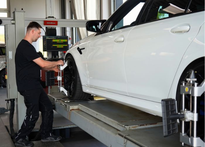 kfz_hildebrand-achsvermessung-700x500 Mitarbeiter führt in der Kfz-Werkstatt eine Achsvermessung durch.