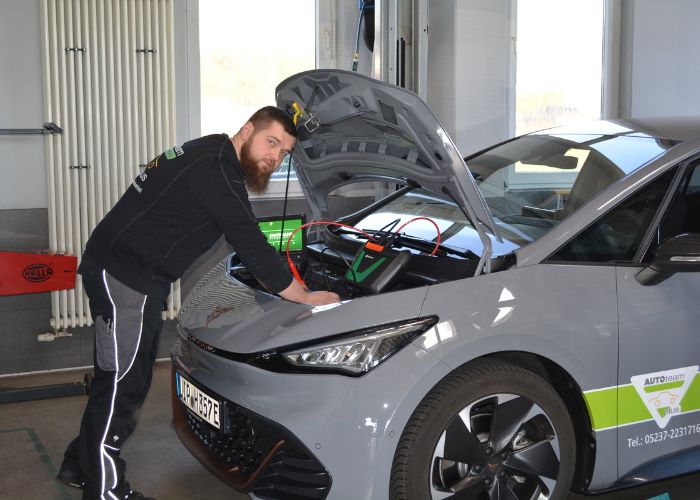 kfz_hildebrand-elektroautos-700x500 Mitarbeiter vom Kfz-Meisterbetrieb Hildebrand repariert ein Elektroauto.