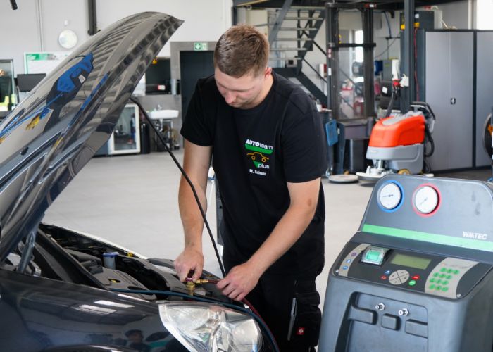 kfz_hildebrand-klimaanlagenwartung_und_desinfektion-700x500 Mitarbeiter führt in der Kfz-Werkstatt einen Klimaservice durch.
