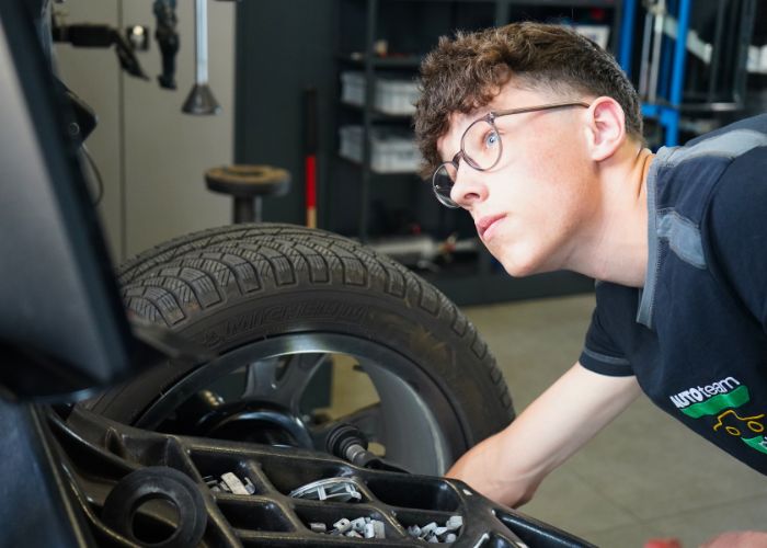 kfz_hildebrand-reifenservice_inkl_einlagerung-700x500 Mitarbeiter führt in der Kfz-Werkstatt einen Reifenservice durch.