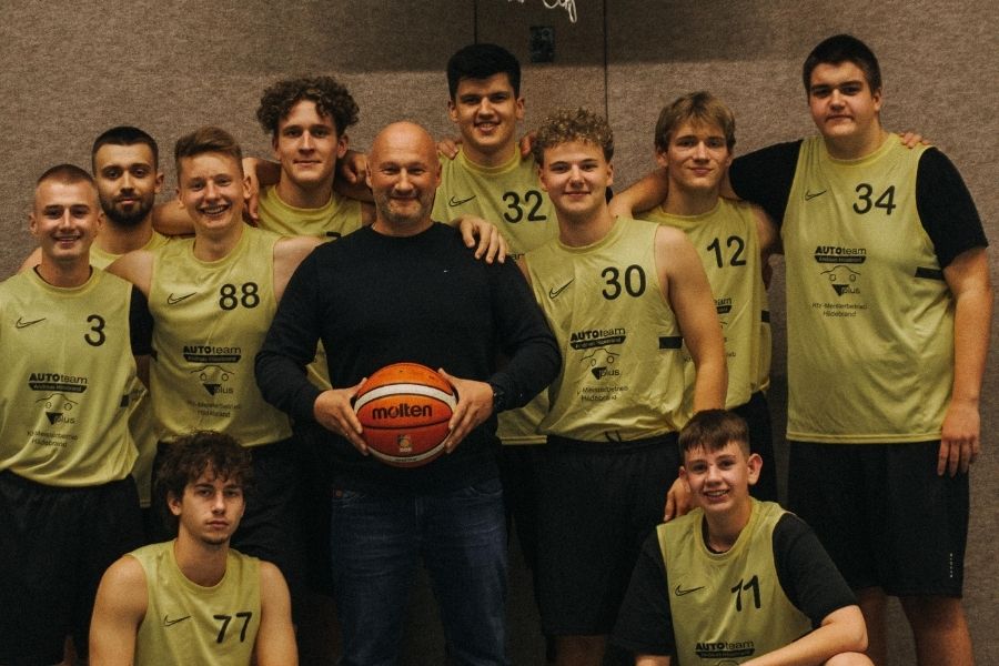 Geschäftsführer von Kfz Meisterbetrieb Hildebrandt steht mit dem Basketball Team von TuSG Augustdorf zusammen.
